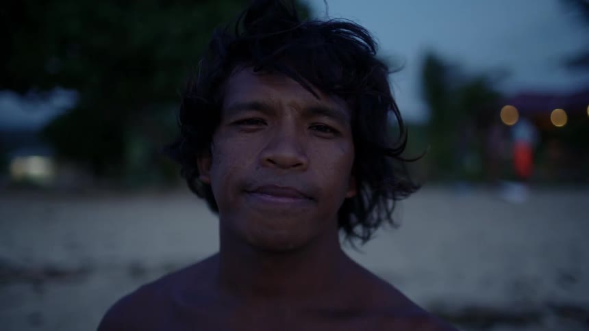 A man standing on a beach looks forward
