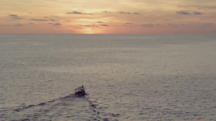 A boat motors out into the ocean