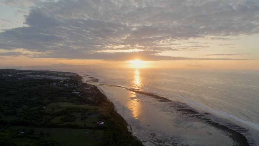 An aerial view of an ocean coast at sunset