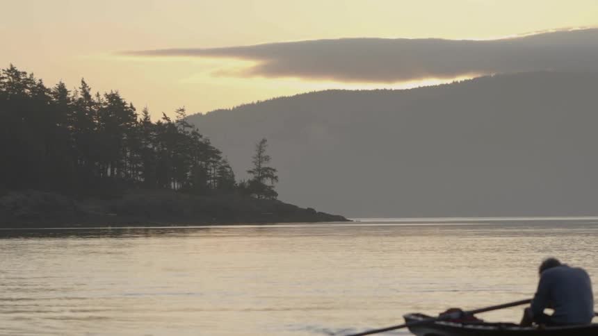 Man sits in a boat in a middle of a large lake