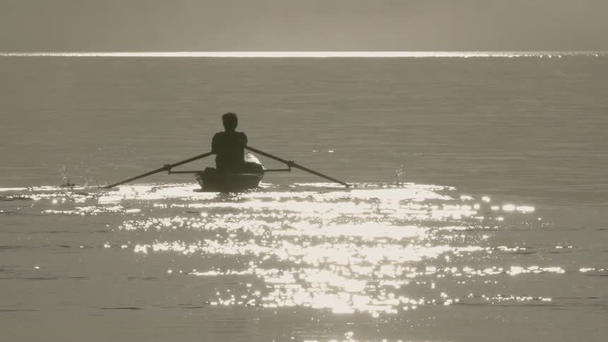 A man rows a boat on a lake