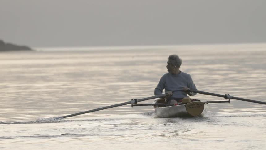 A man is rowing a boat on water
