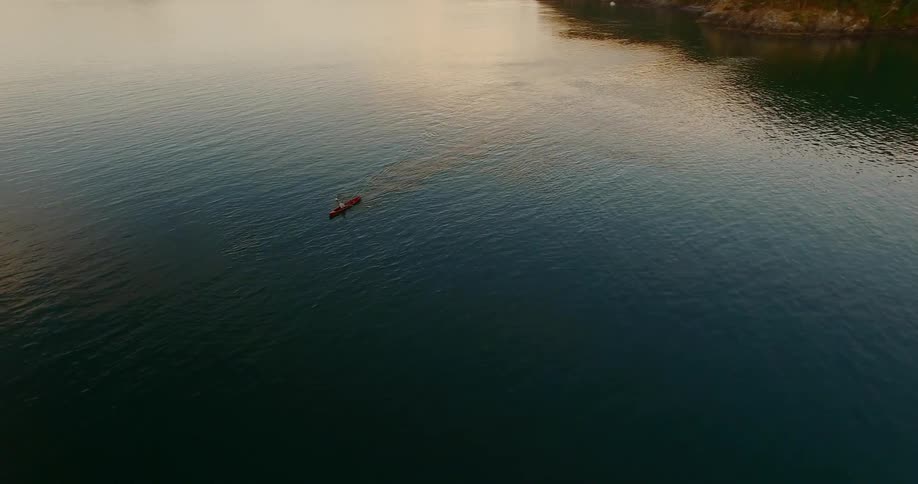 An aerial view of a rowboat on a body of water