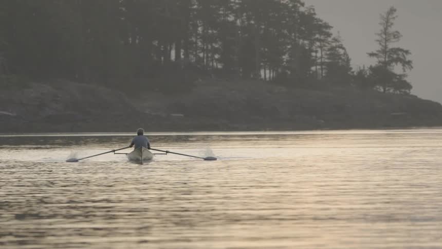 Man rows canoe near shore
