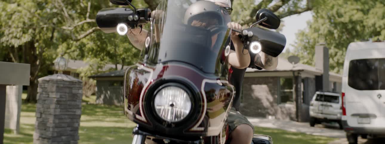 A man and child ride on a powered scooter