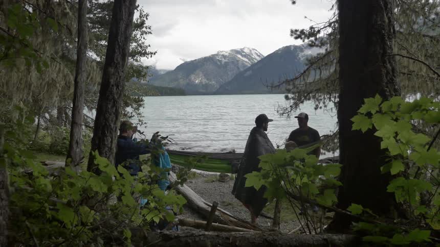 Campers packing up near a mountain lake