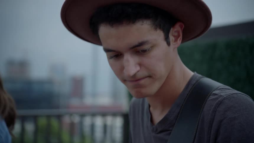 A man in a hat playing the bass guitar