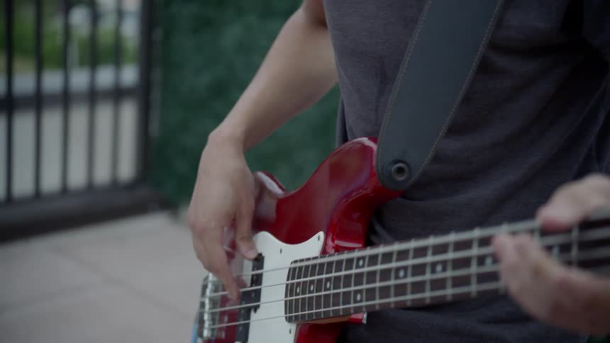 A young man plays a bass guitar