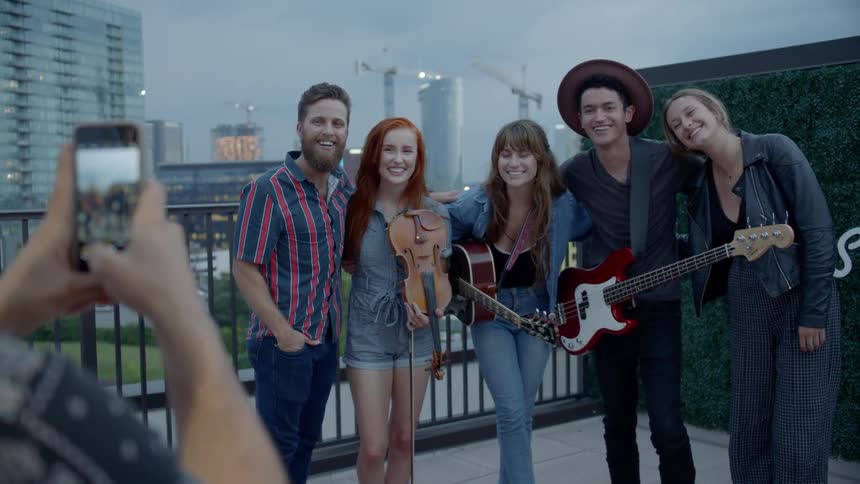 Couple posing for a picture with three young musicians