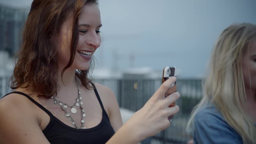Two women taking photos with their smartphones