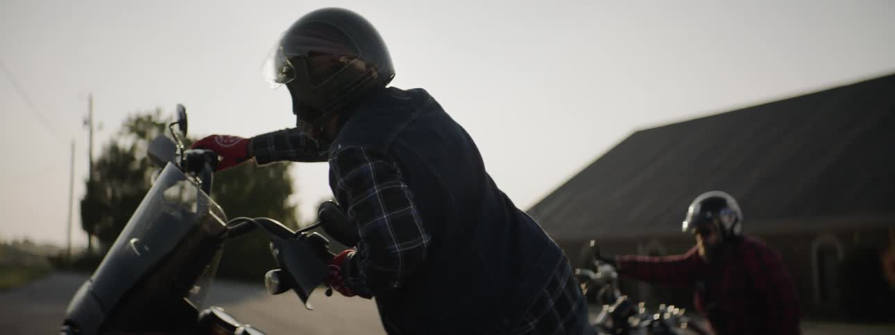 Two people prepare to ride motorcycles