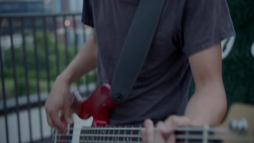 A man in a hat plays bass guitar