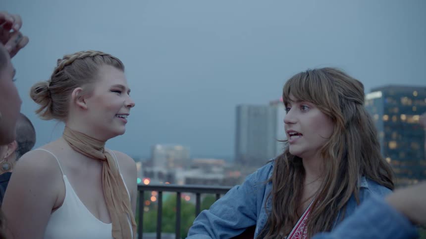 A group of girls talk together on a balcony