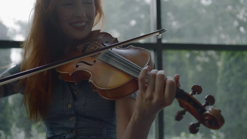 A woman is playing a musical instrument indoors