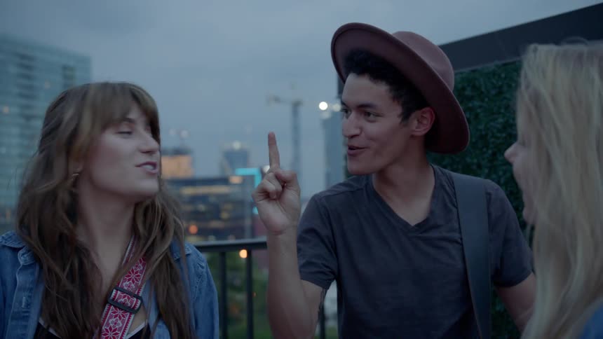 Group of young people stand around and laugh