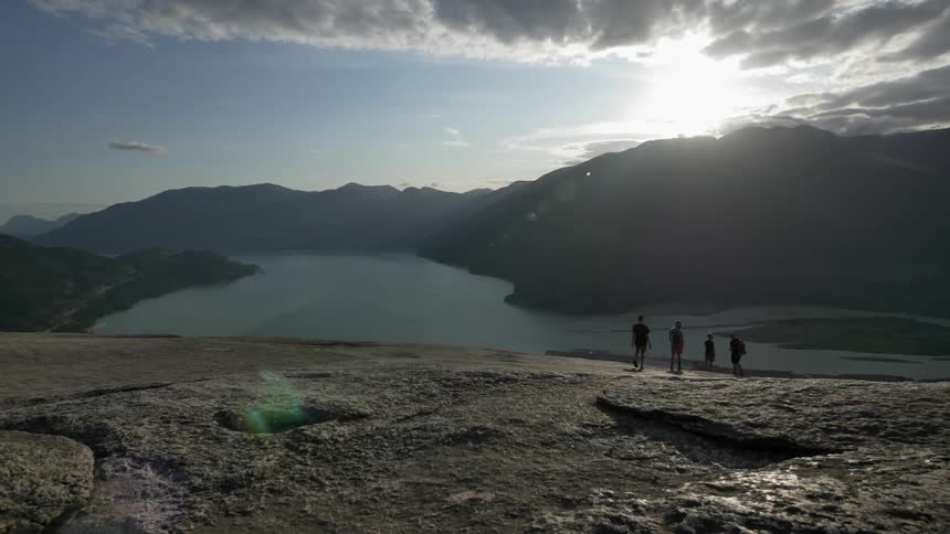 Group of people walking on the dirt to a body of water