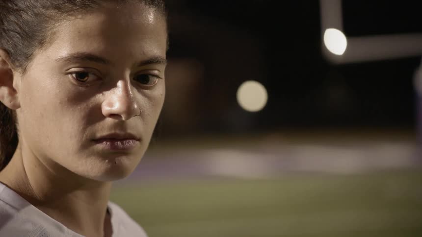 A soccer player concentrates before taking a shot at night