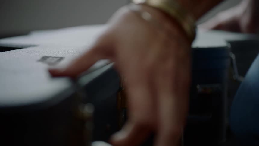 A person opens a guitar case