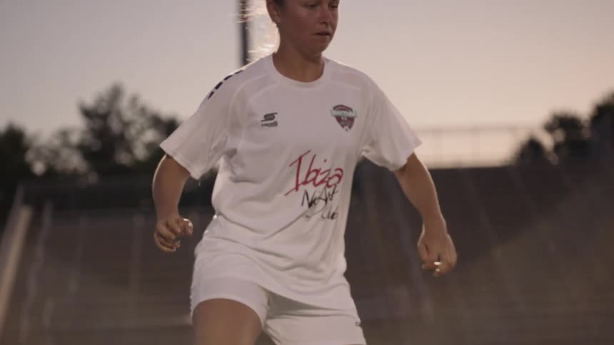 Women's soccer player passes the ball