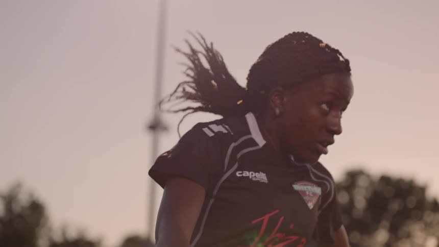 A woman hits a soccer ball with her head