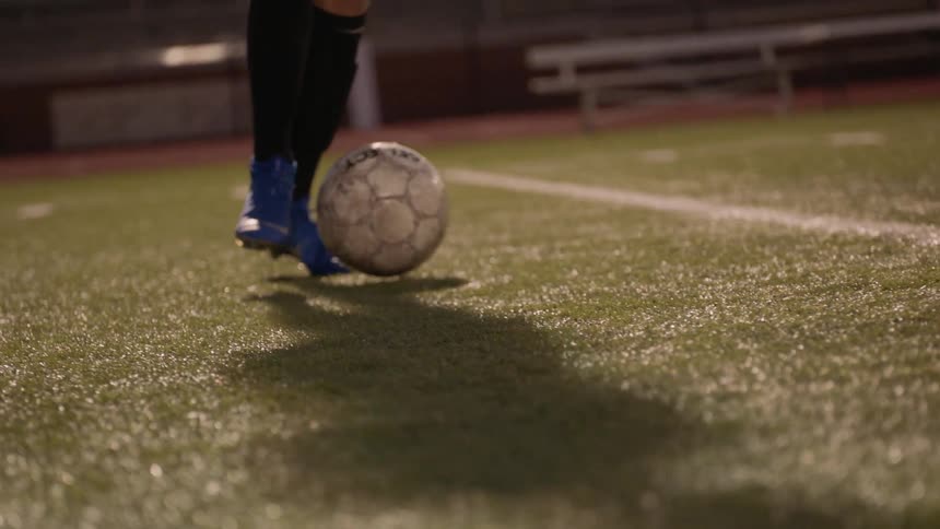 Women football players play football in the stadium under the stadium lights at night