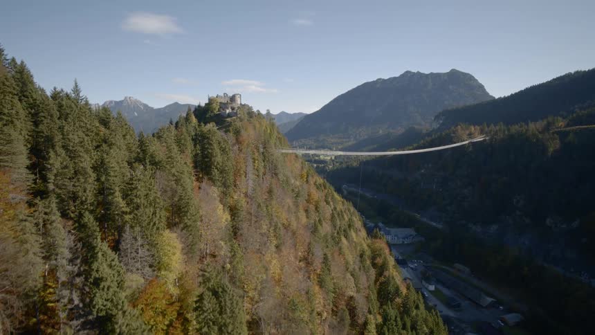 The camera flies near a canyon with a bridge over it