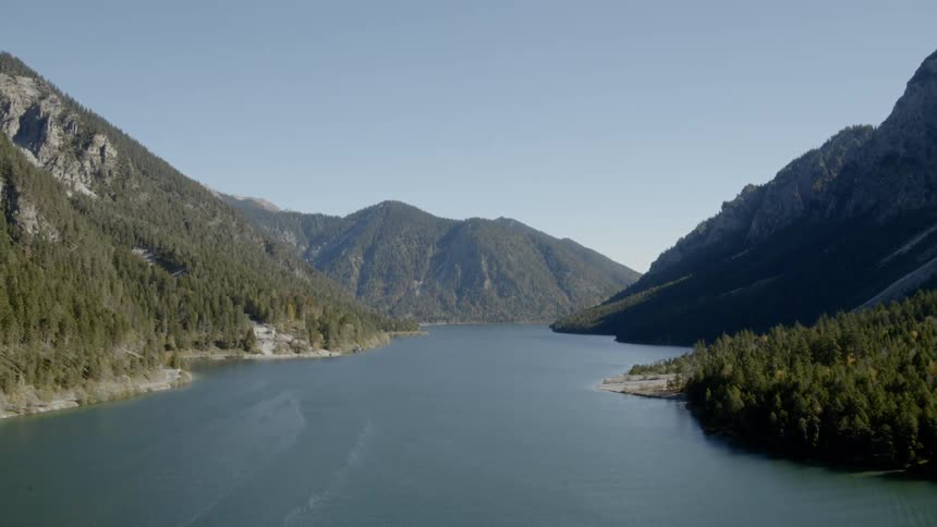 An aerial shot of a lake surrounded by mountains