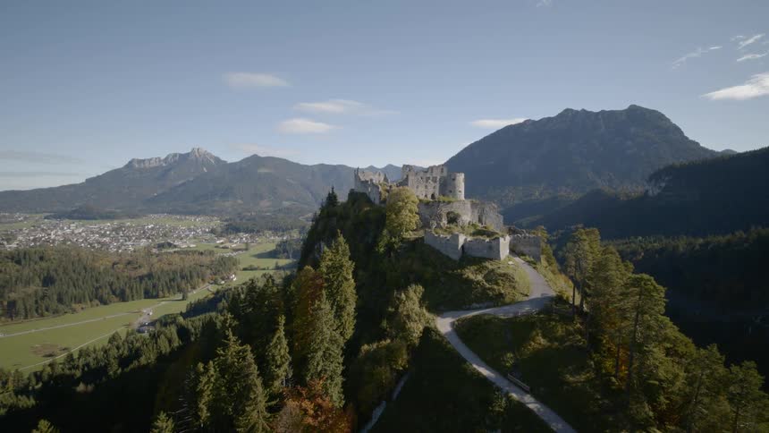 A windy road leads to a castle at the top of a hill