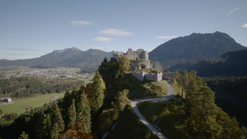A castle sits on the top of a promontory at the end of a long and winding road
