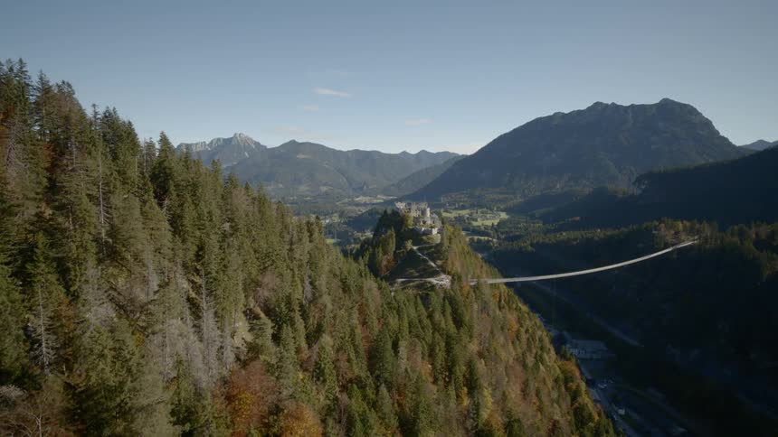 A bridge over a river with the mountains in the background