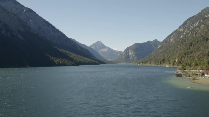 Village borders water near mountains