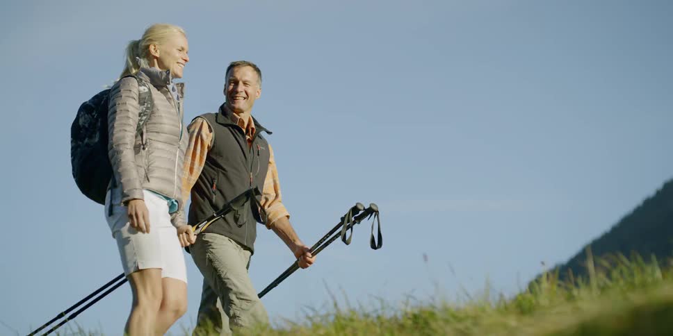 A man and woman walking along a grassy area