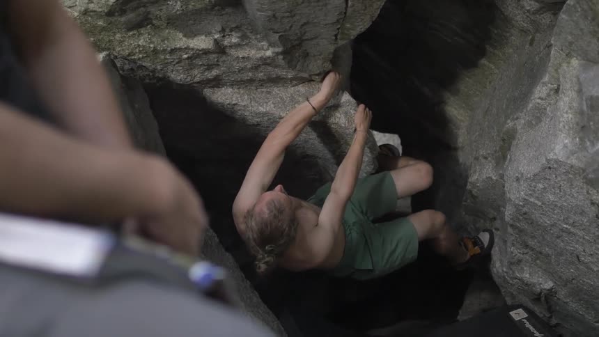 Man desperately trying to climb up rocks