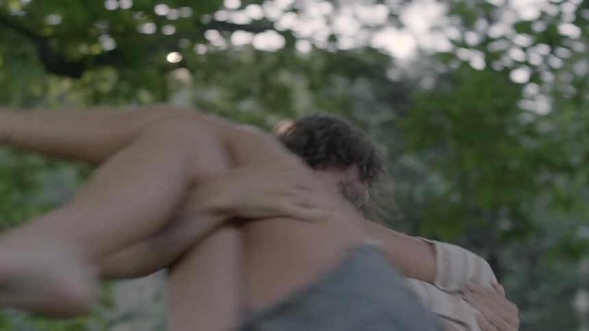 A man holds a woman in his arms and spins around