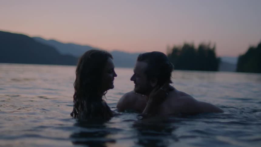 Two people in a lake caressing and kissing