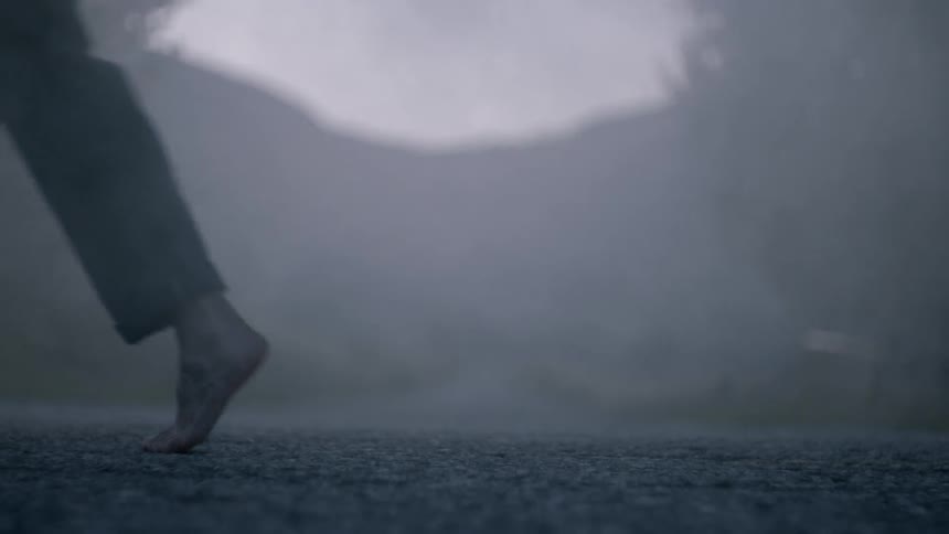 Barefoot woman and man walks in opposite directions at dusk