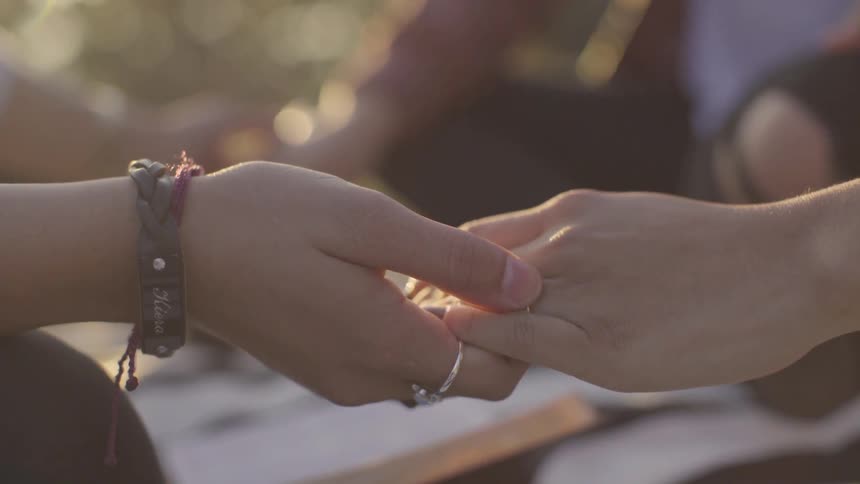 Two people hold hands during a ceremony