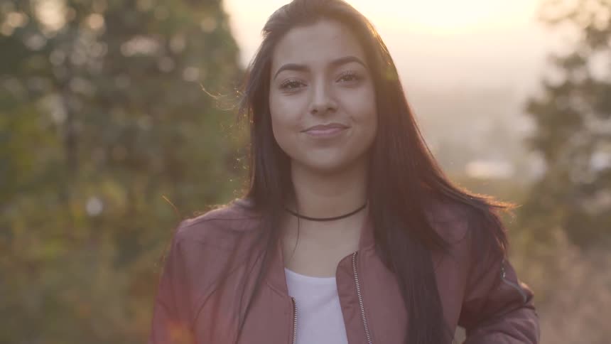 Young woman plays with her hair then looks up at the camera