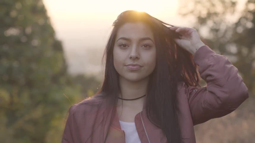 Young woman looking at the camera at sunset