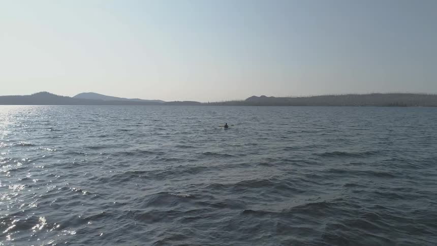 A canoeist paddling a canoe in a lake