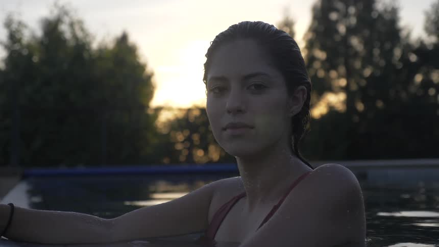 A woman looks over while in a pool