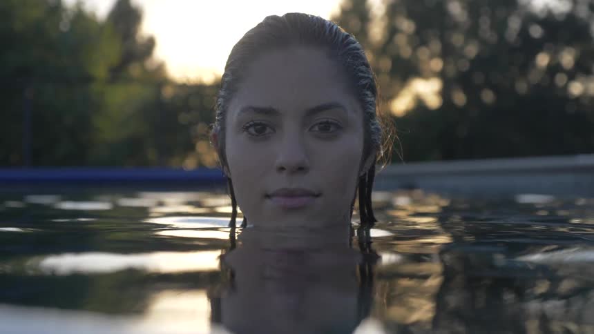 A woman standing in a pool with the water up to her chin