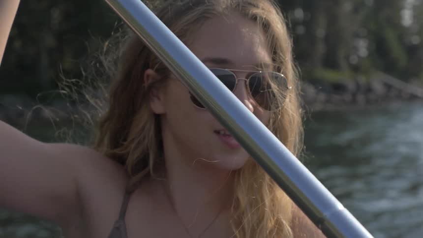 A woman is rowing a boat in the water