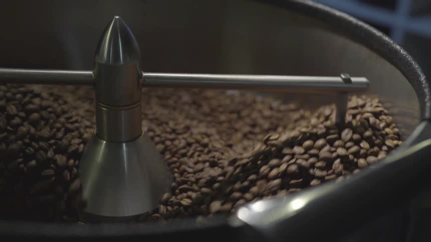 A coffee roasting machine turns coffee beans