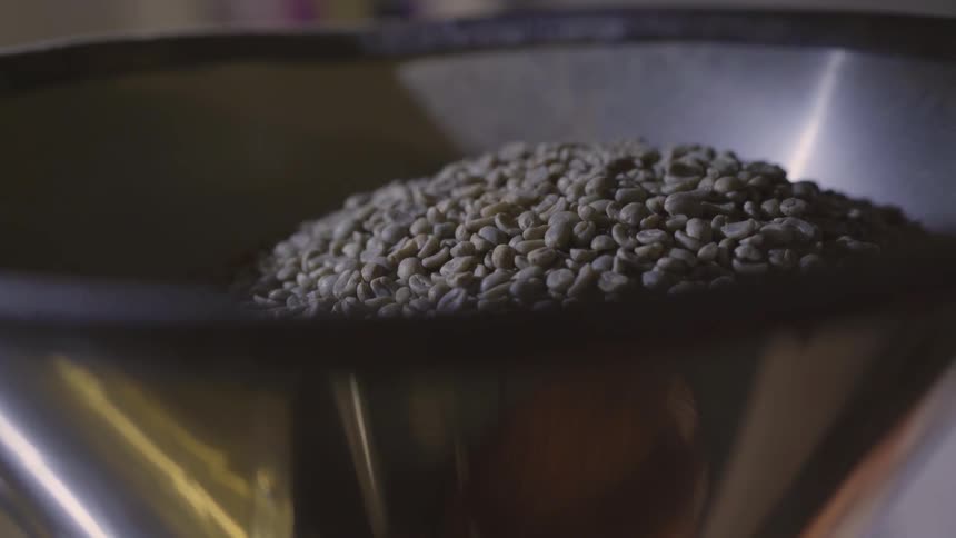 Coffee beans move in a hopper