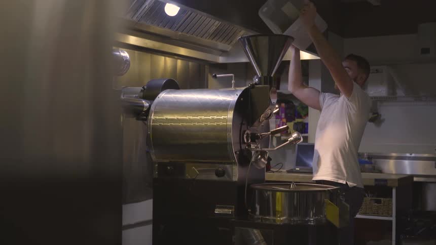 A man pours ingredients into a machine