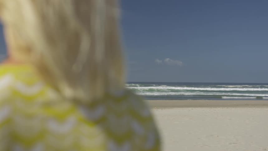 A woman is looking at the beach outdoors