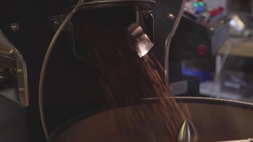 Beans pour out of a commercial pipe into a large sifting bowl