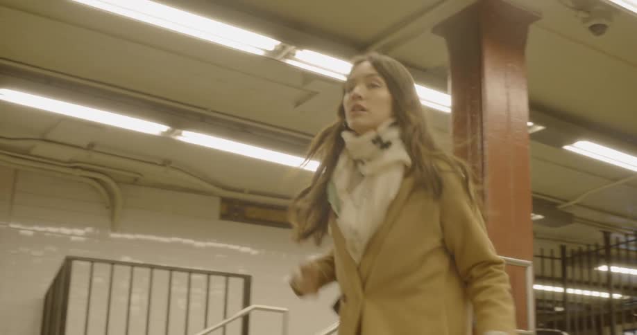 Woman passes through turnstile and boards subway train