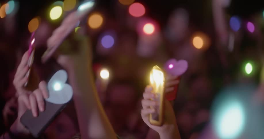Audience holding up mobile phones with flashlight on